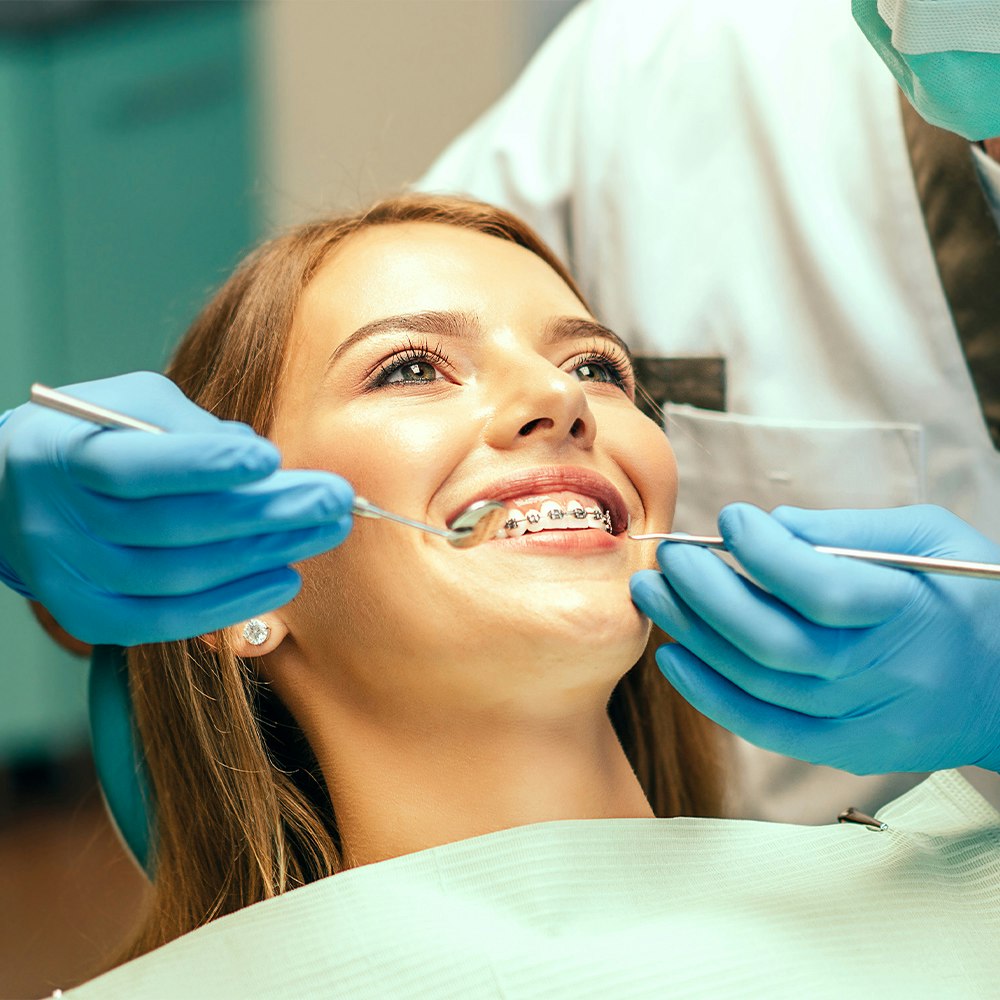 a young lady getting braces at the dentist's