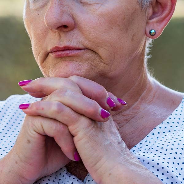 Woman folding hands under chin