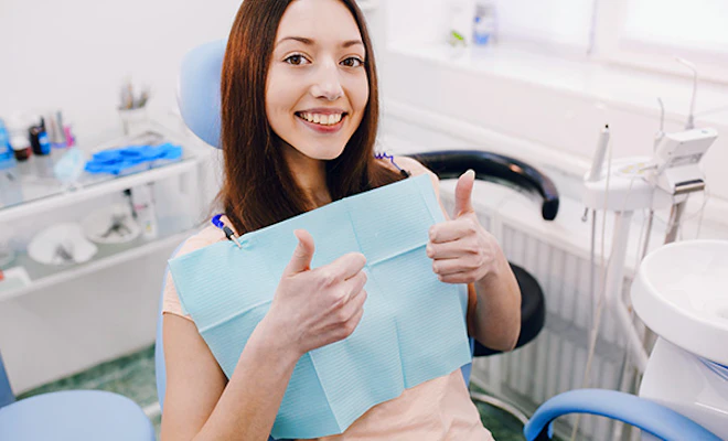 woman giving thumbs-up in dental chair