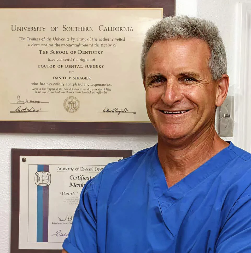 Daniel E. Stragier, DDS in front of his framed accolades