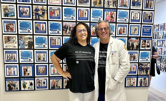 Dr. with patient in front of testimonial wall