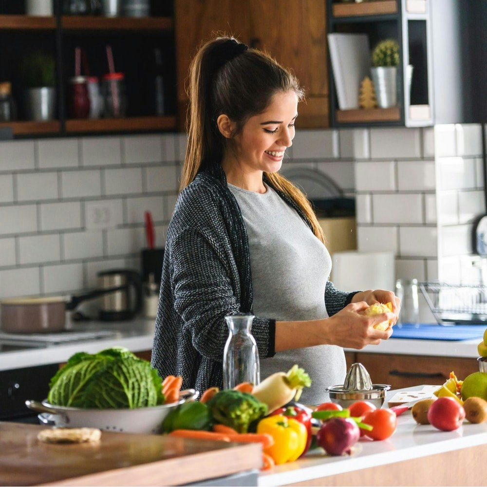 Pregnant woman cooking a healthy meal