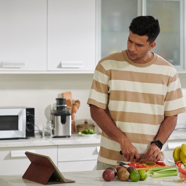 Man looking at a recipe while cooking