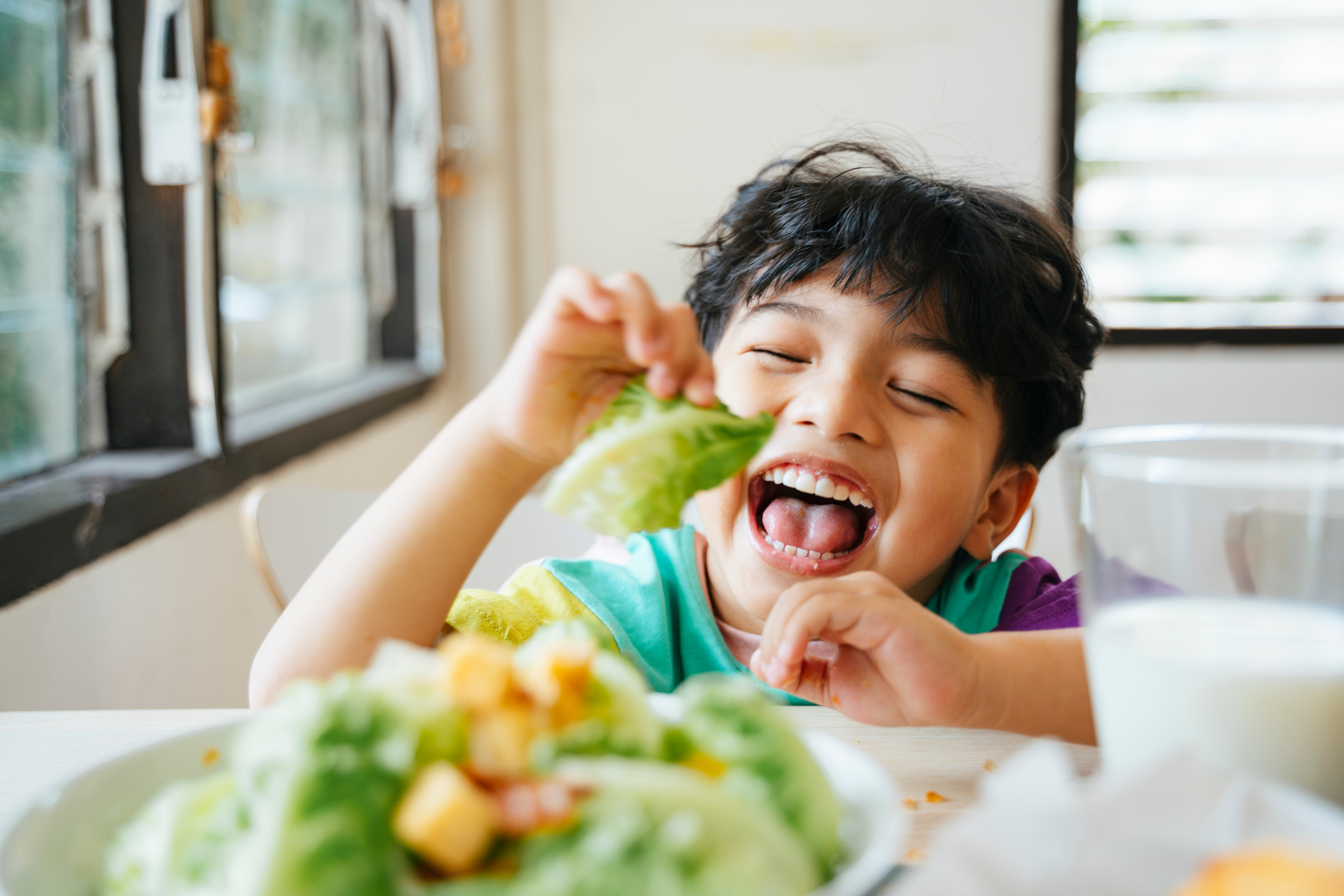 Toddler eating salad