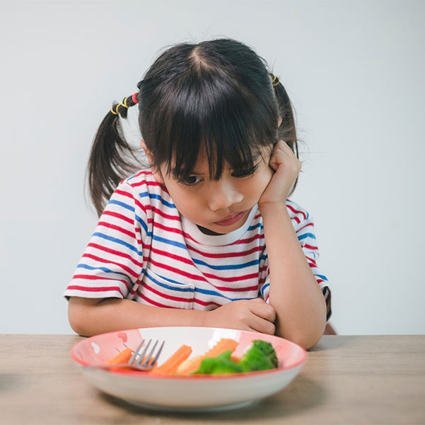 Girl frowning at vegetables