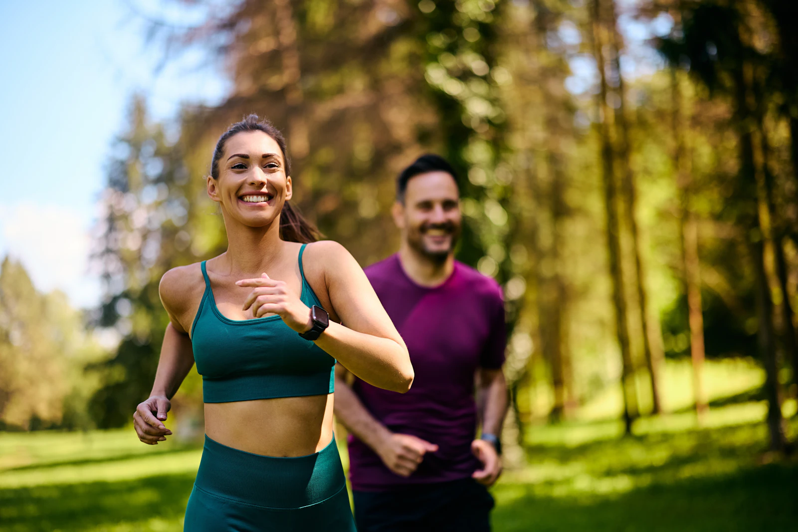 Couple running together through a park