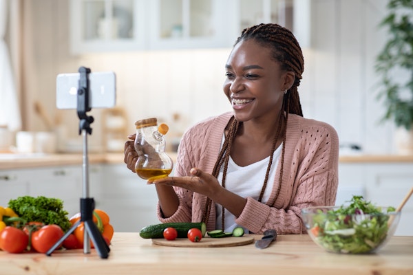 woman watching her phone while cooking