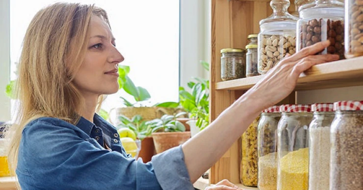 Woman reviewing items in a home pantry