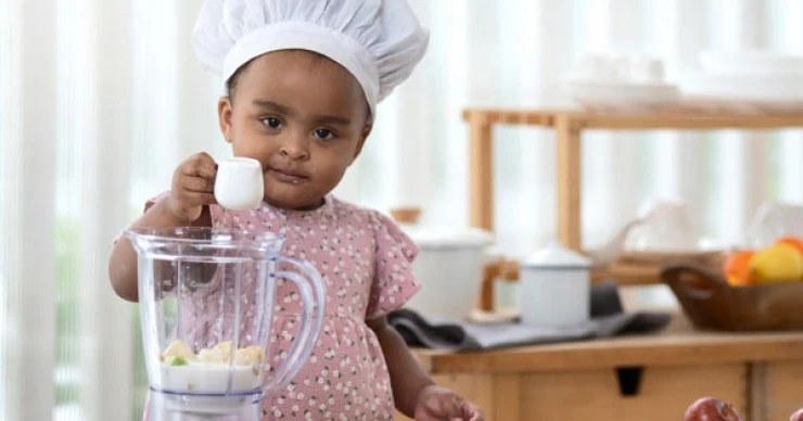 Young child pretending to cook in a play kitchen