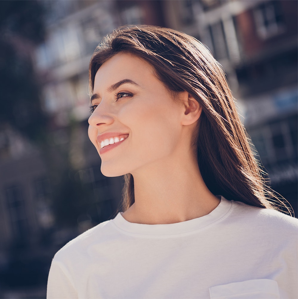 Young, beautiful woman smiling outside