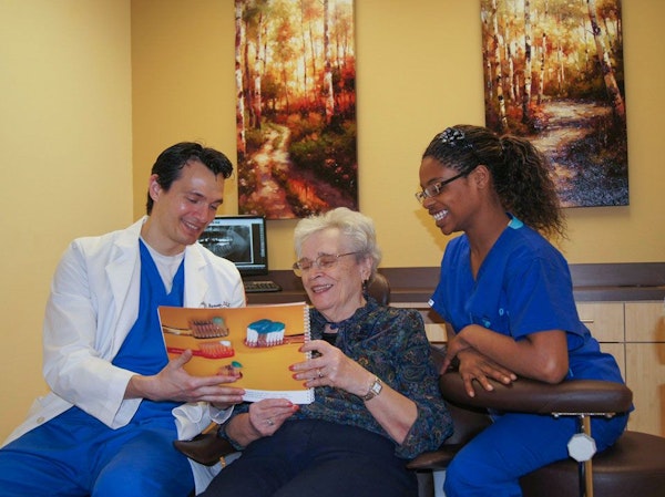 Dr. Montoya with a patient reading a dental brochure