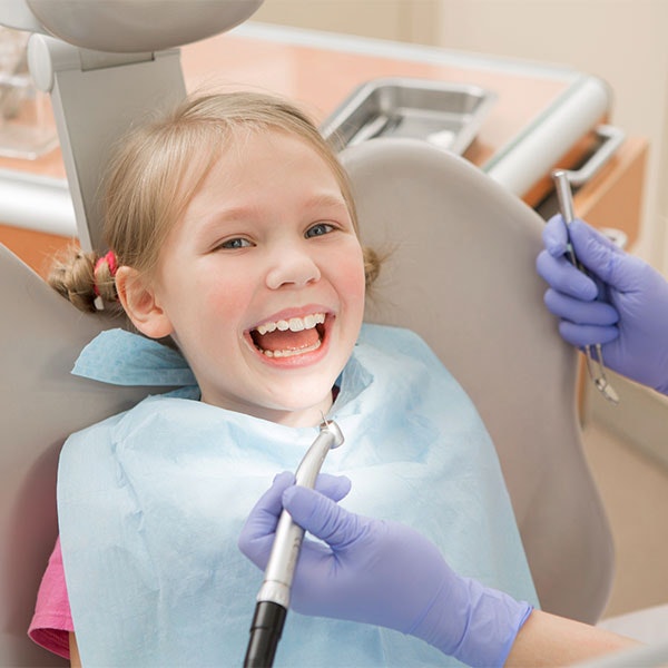 Young girl smiling in a dental chair