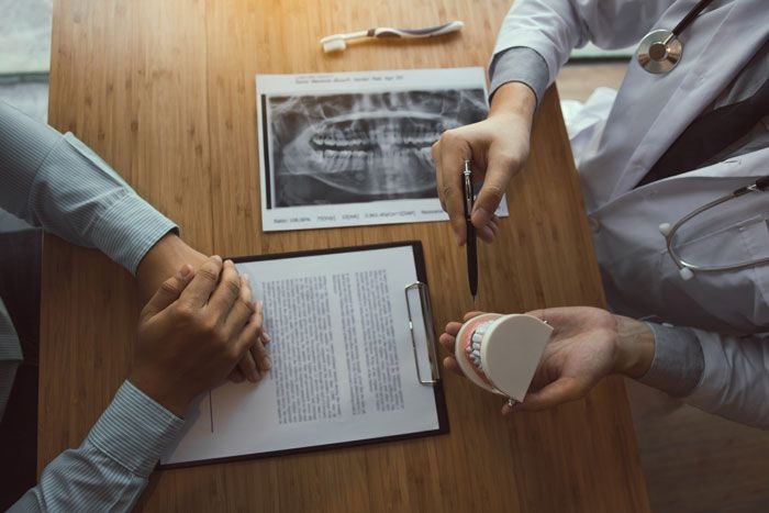 dentist showing patient a mouth mold
