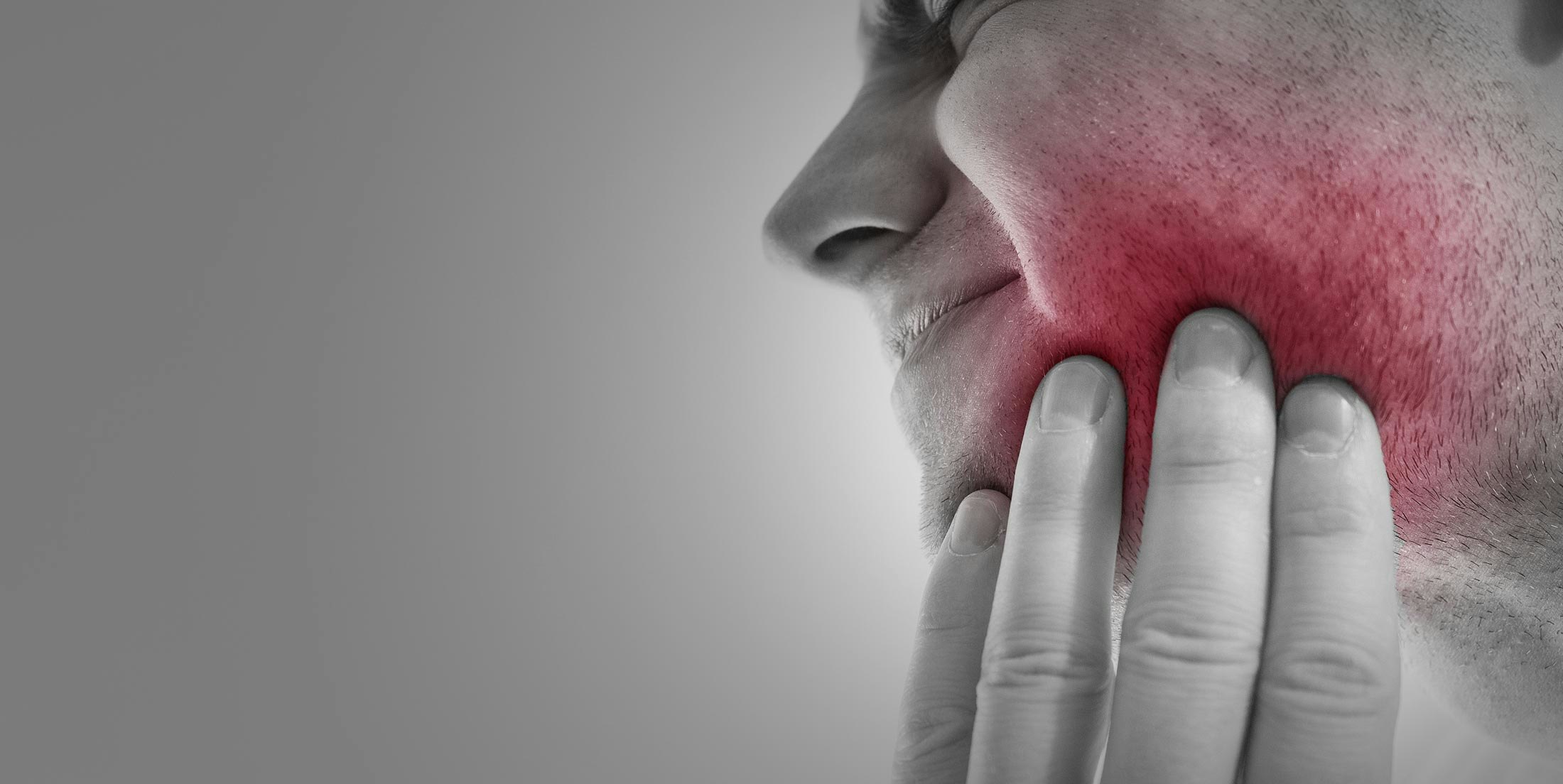 Woman holding hand to jaw in pain