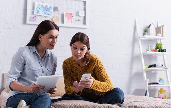 Two women exploring dental options on phone