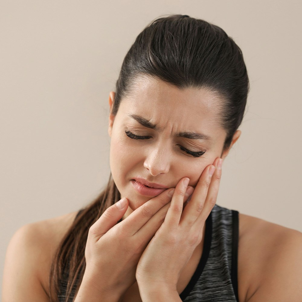 Woman holding a hand to her jaw