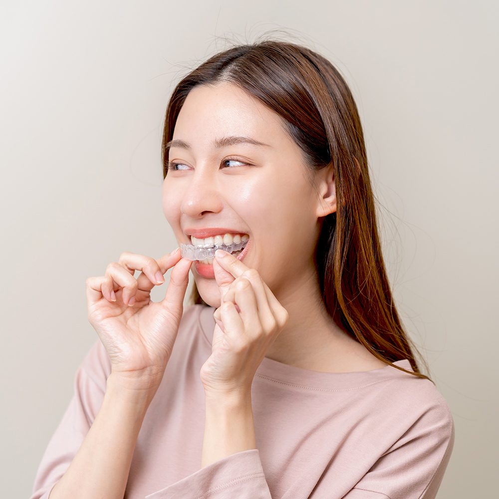 woman putting in clear aligners