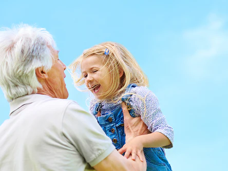 Older man playing with young girl