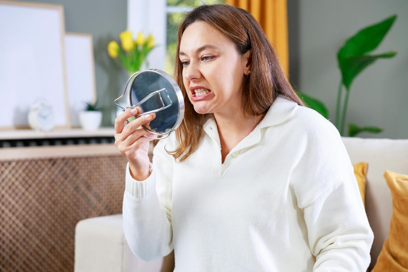 woman examining her teeth in the mirror