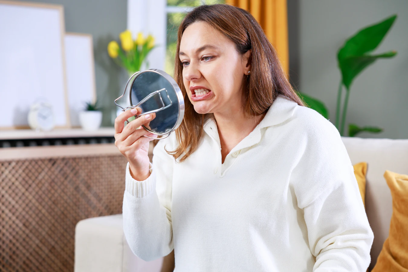 woman examining her teeth in the mirror