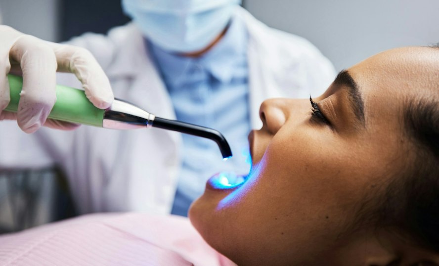 Patient receiving dental bonding treatment with a curing light at Dearborn Family Dentistry