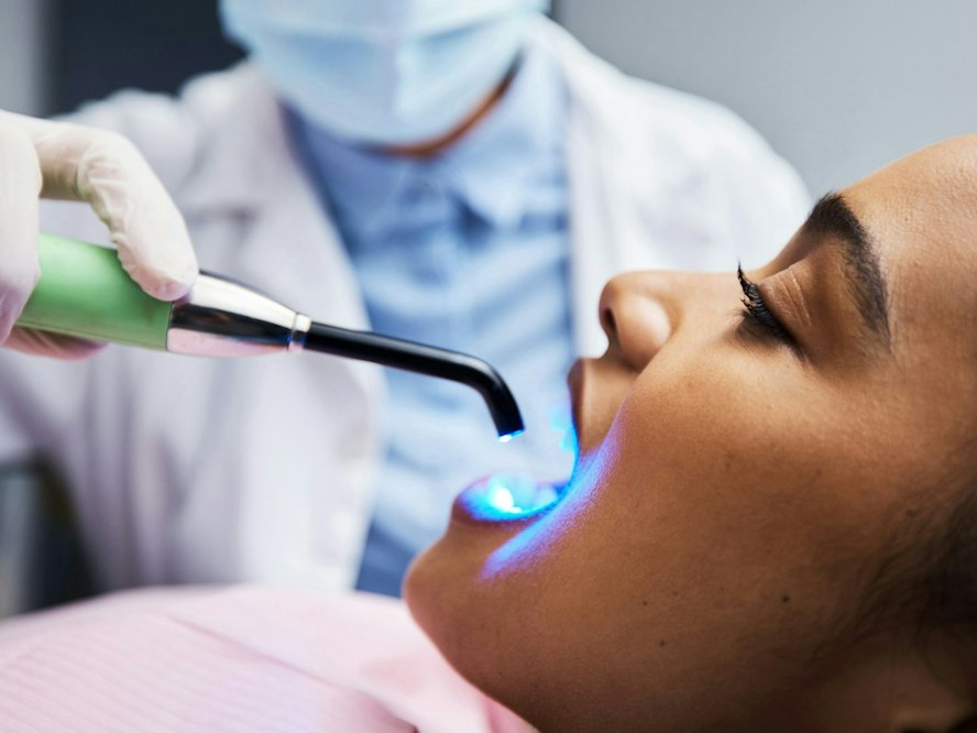 Patient receiving dental bonding treatment with a curing light at Dearborn Family Dentistry