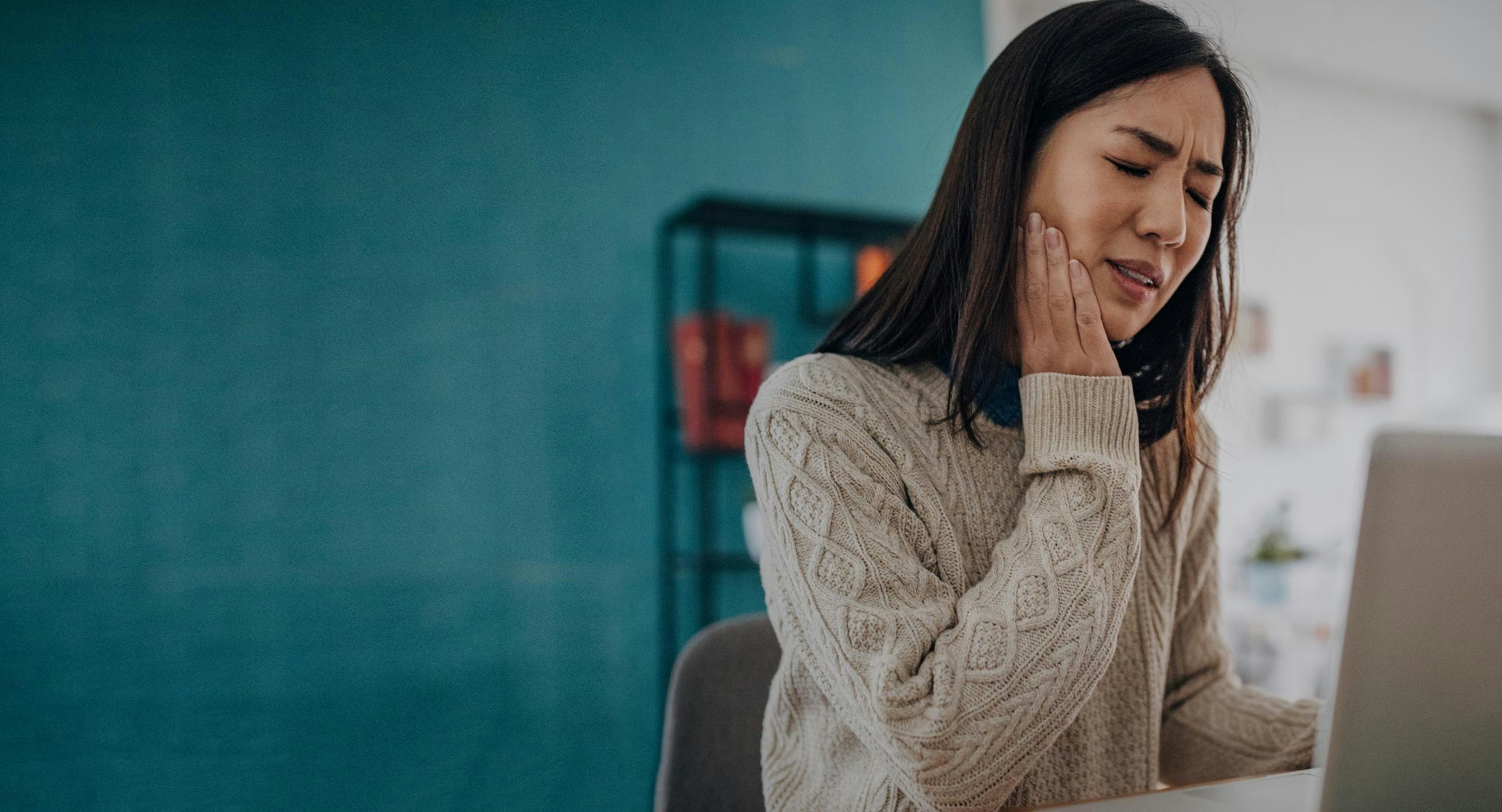 woman holding jaw in pain