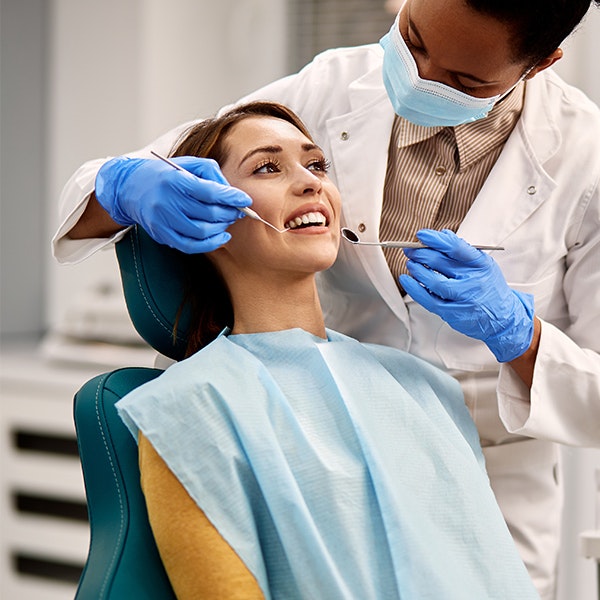 doctor examining woman's teeth
