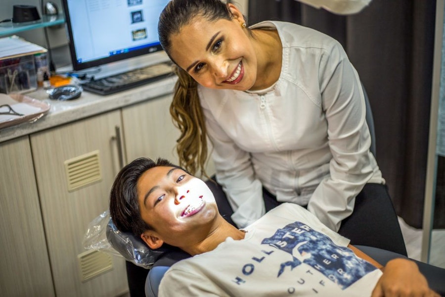 Dr. Falcon and smiling teenager during dental appointment
