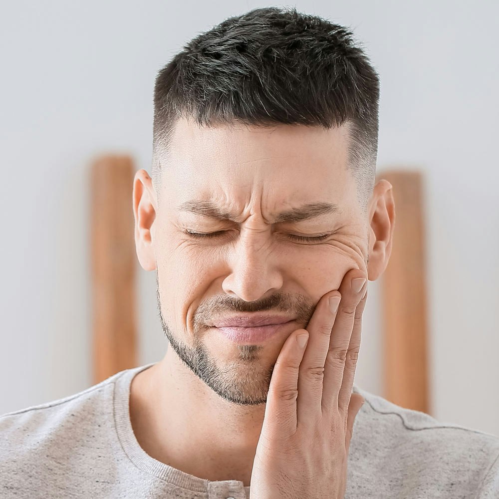 Man holding jaw in pain