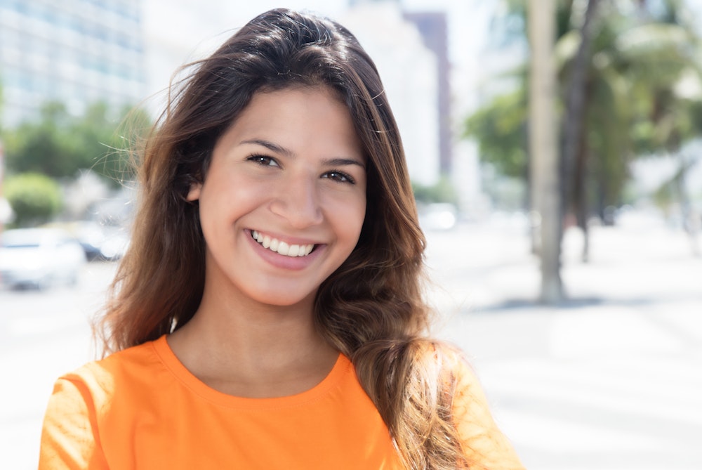 Young woman smiling in an orange shirt