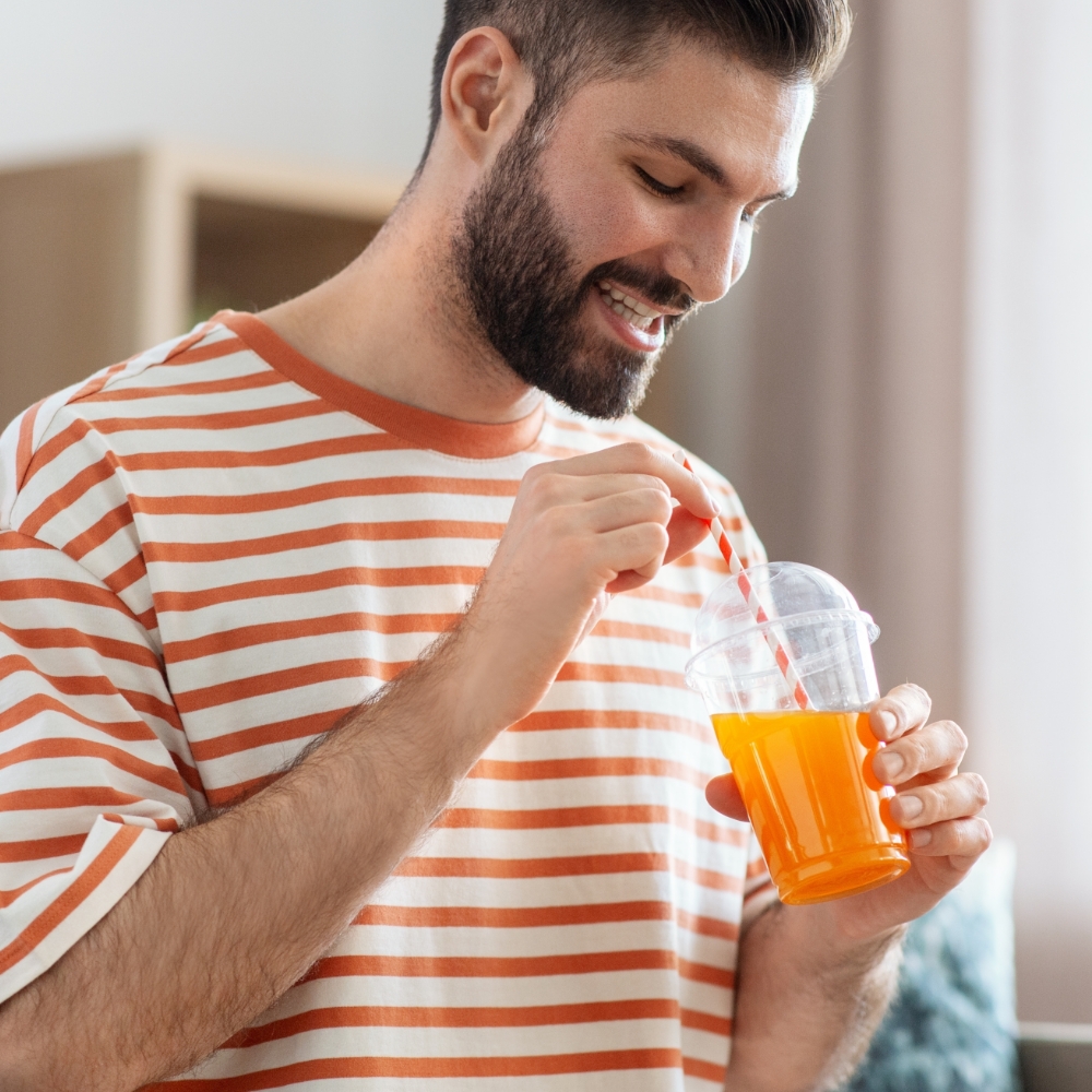 man with veneers drinking with straw