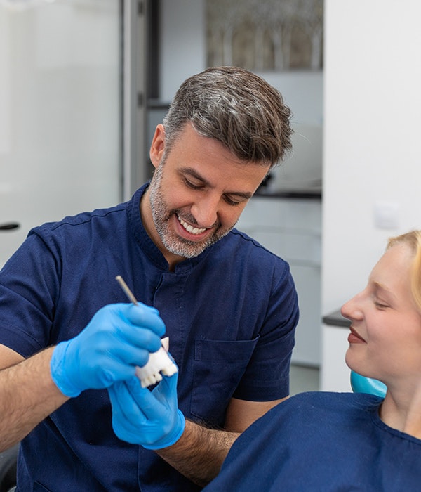 dentist showing model jaw to patient