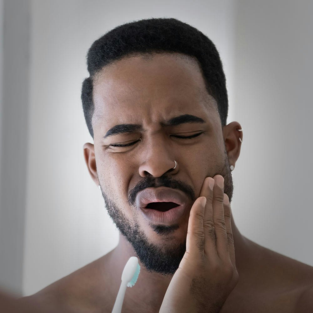 man holding jaw in pain
