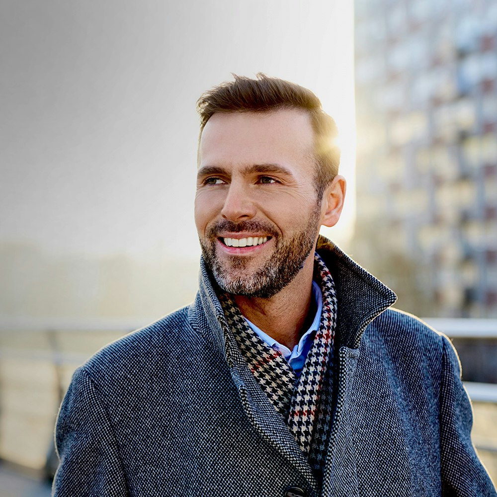Smiling man after dental crowns treatment
