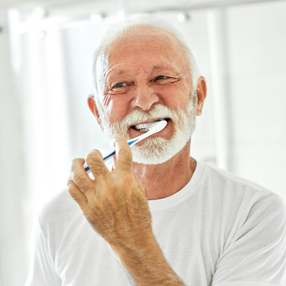 mature man brushing teeth