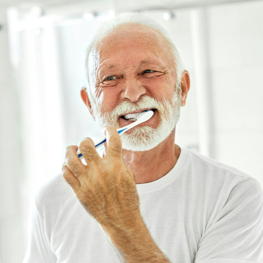 mature man brushing teeth
