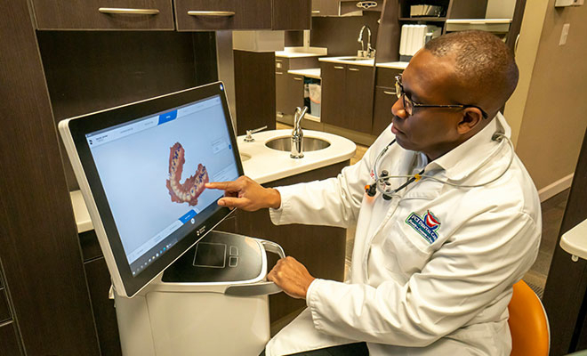 Dr. Saccoh looking at intraoral scanner results