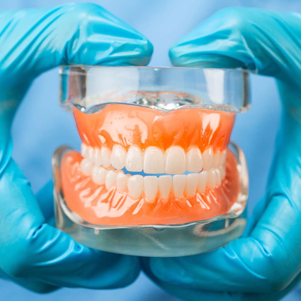 Close-up of a dentist holding implant dentures