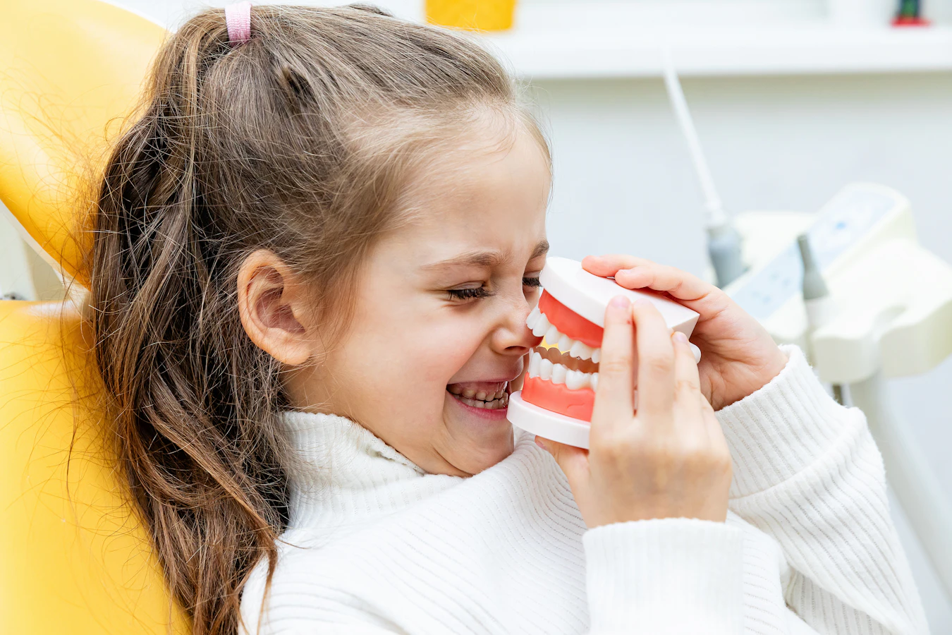 child playing with tooth model at dentist