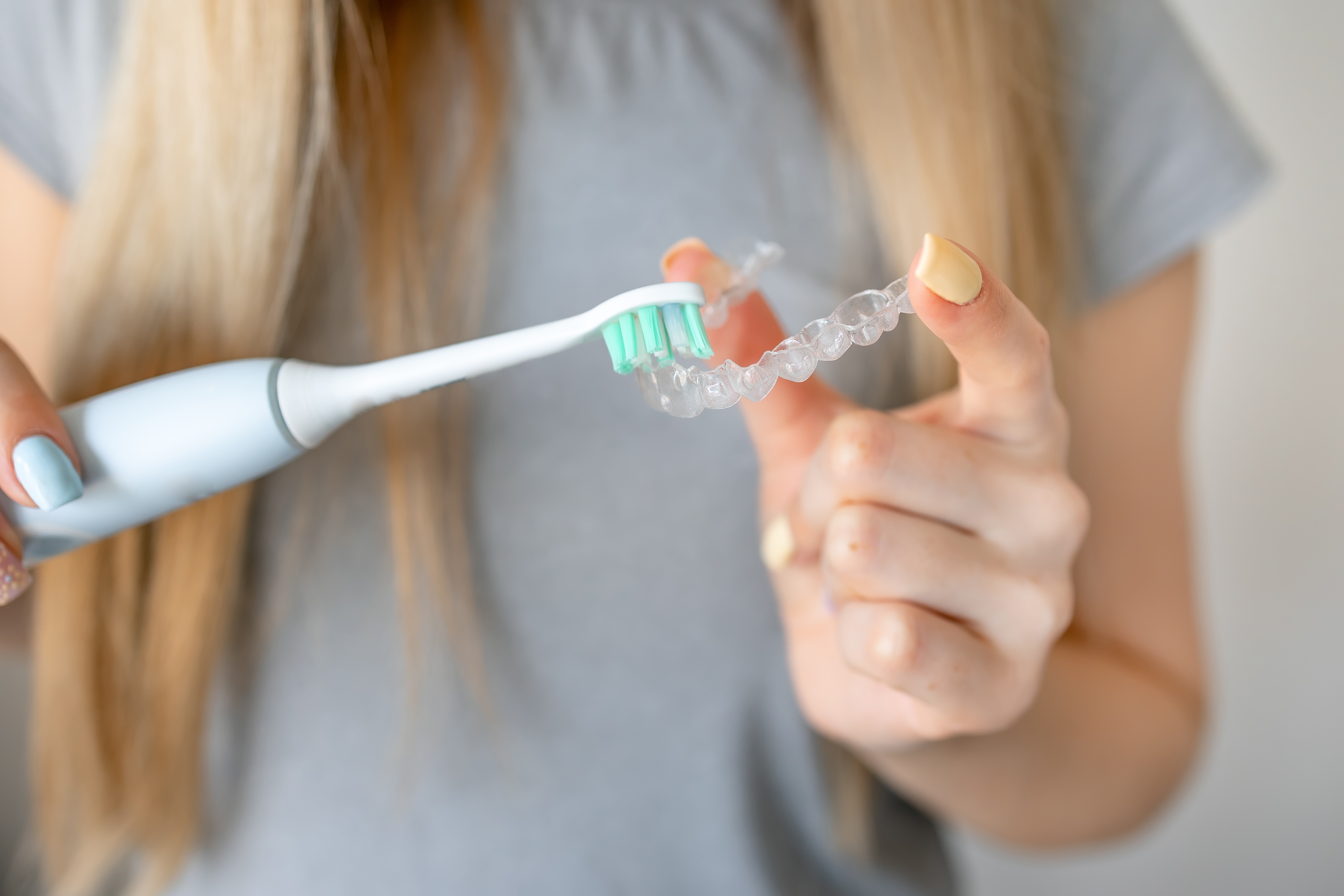 Young woman brushing her aligners