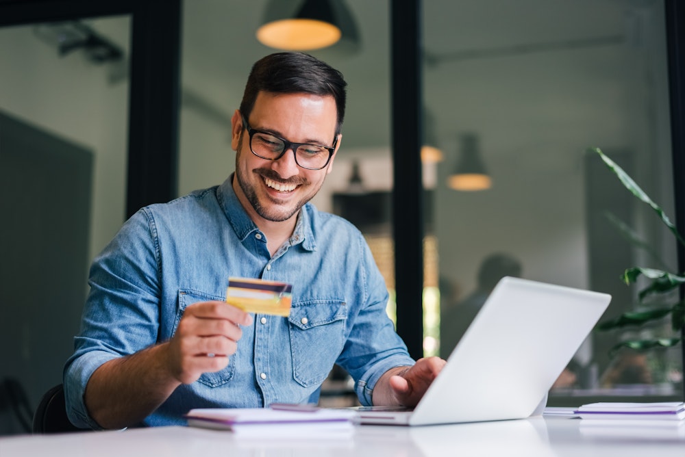 Man holding credit card and smiling