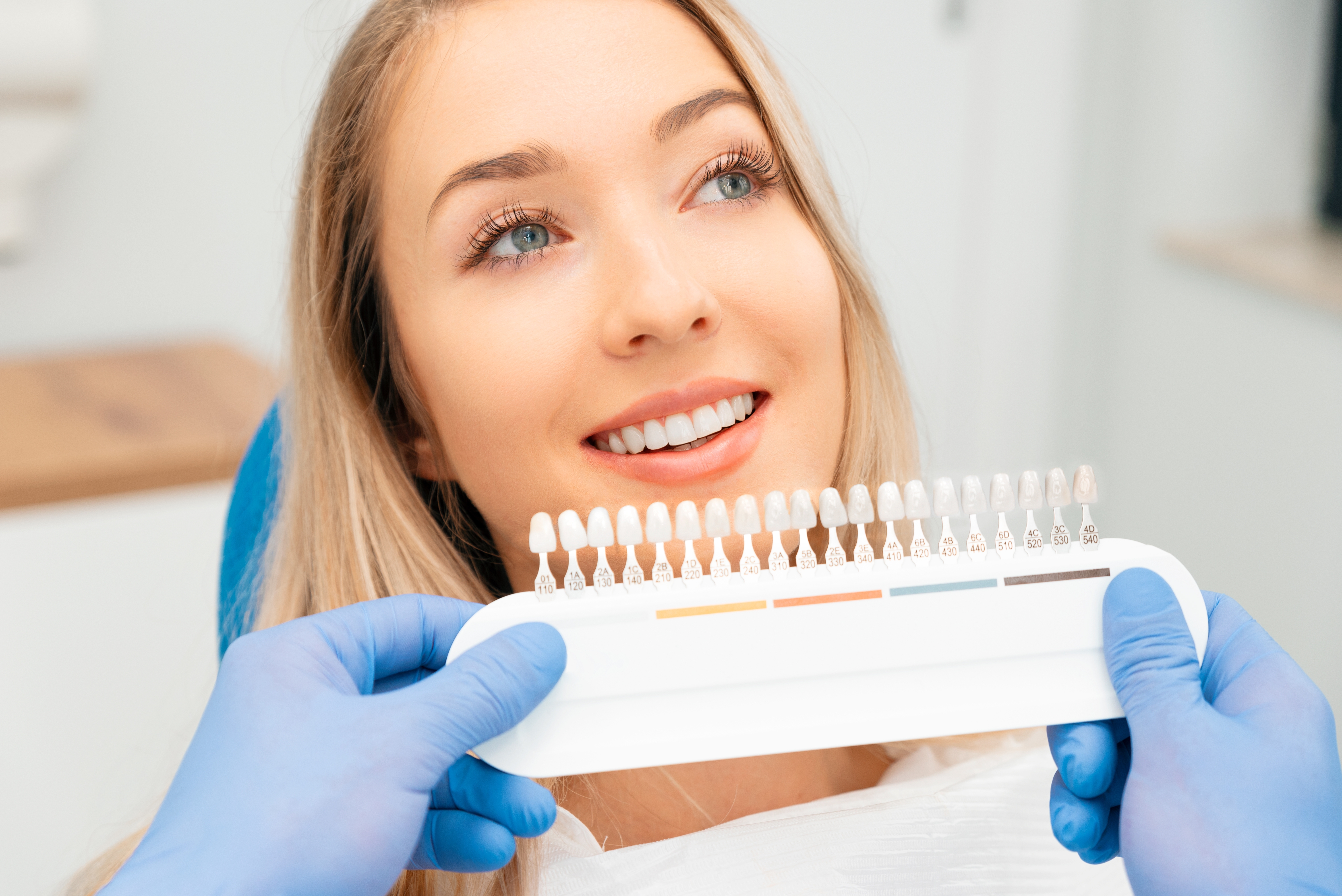 Young woman getting her teeth shade matched for veneers