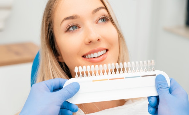 Young woman getting her teeth shade matched for veneers