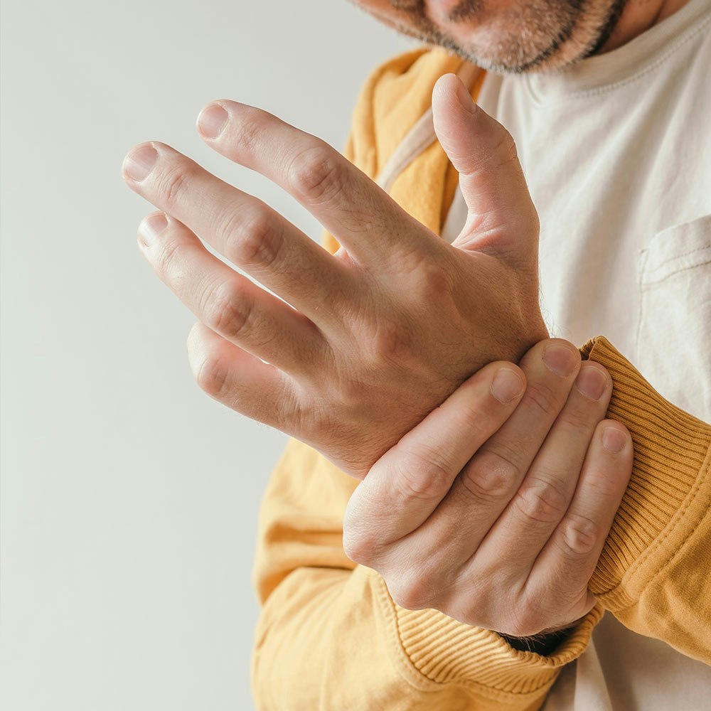 Man holding wrist in pain because of ganglion cyst