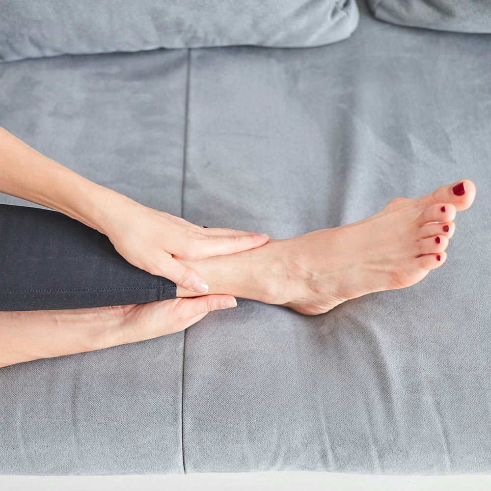 Woman gripping ankle in pain