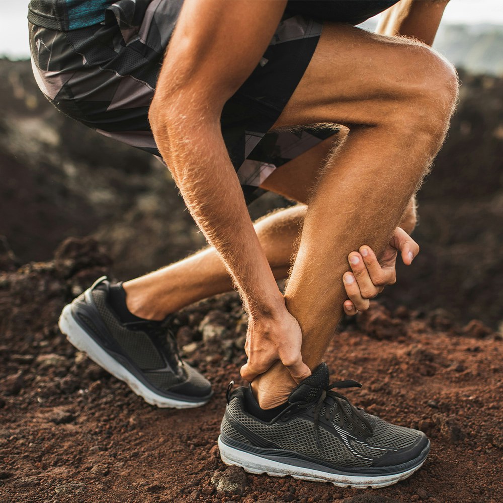 Person clutching ankle in pain