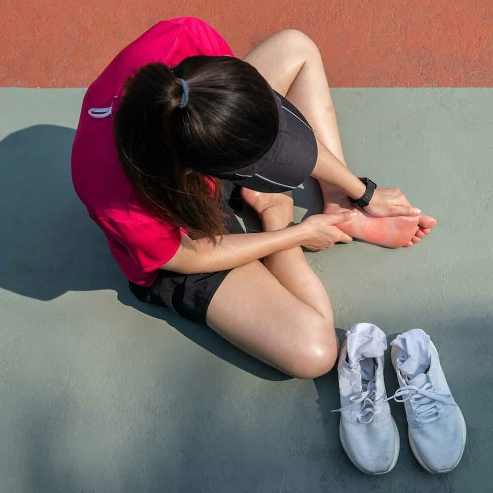 Tennis player holding foot in pain