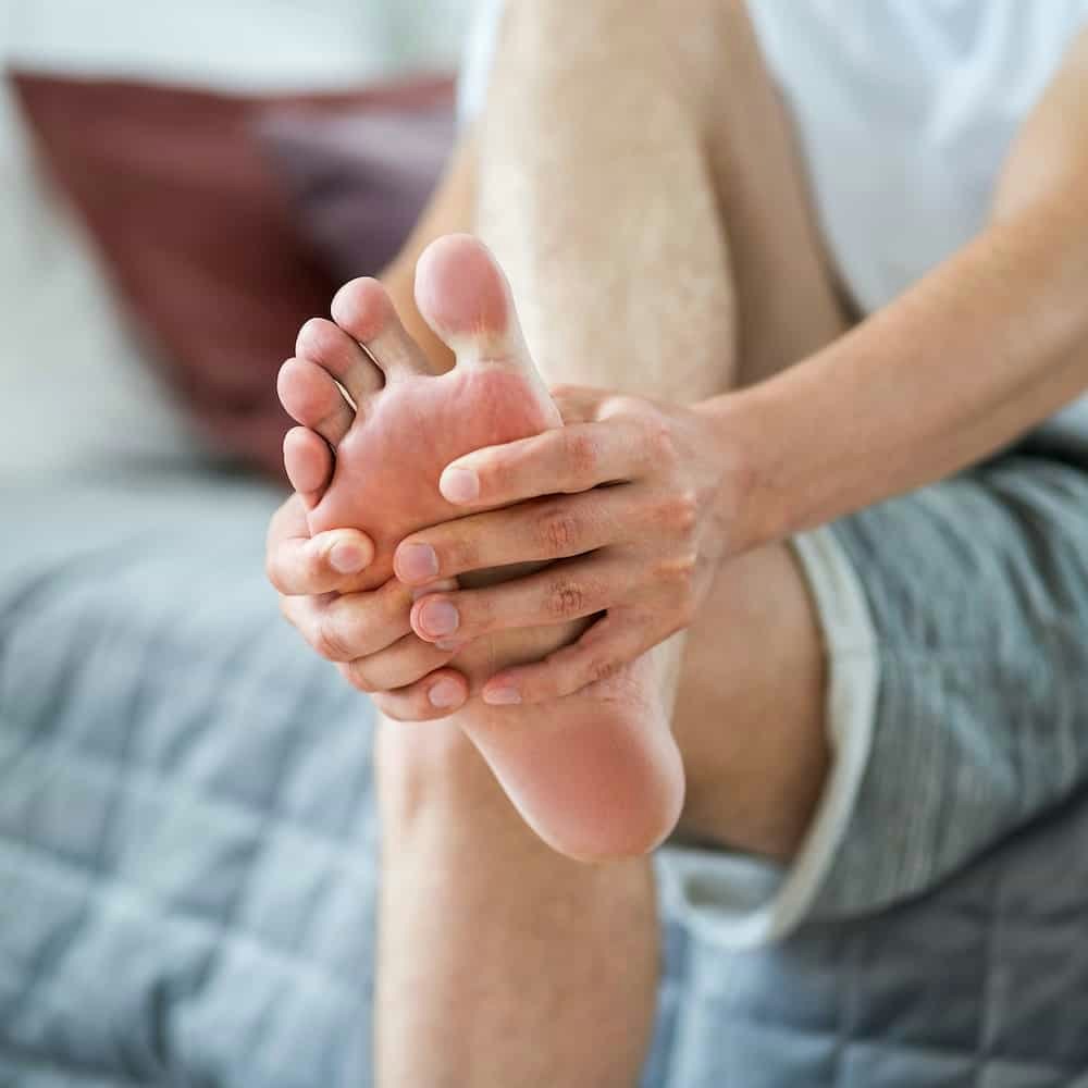 Person holding foot in pain