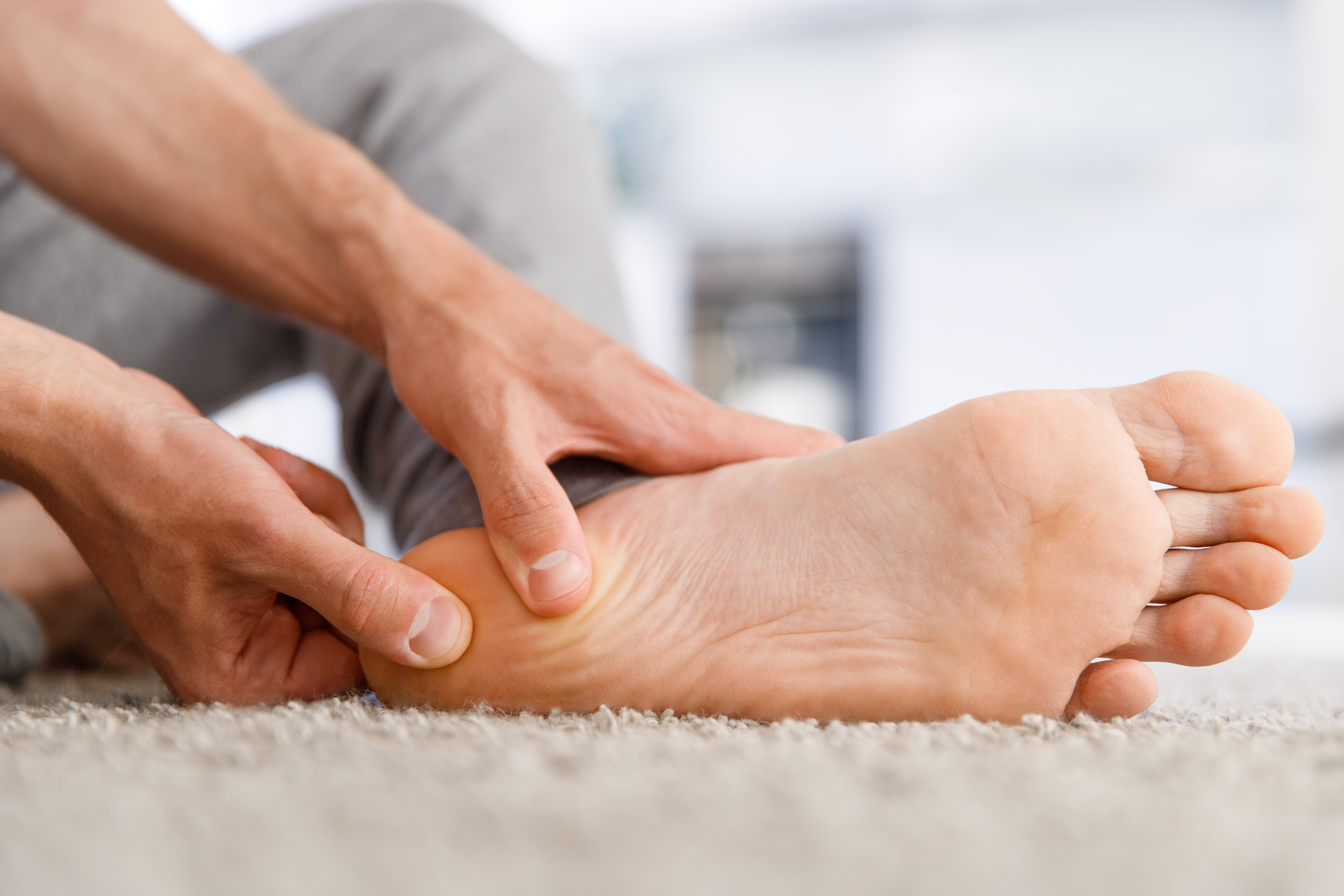 Man rubbing painful foot
